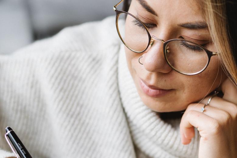  Thoughtful young woman preparing for exam at home 